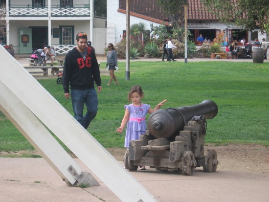 Girl walks past cannon in Old Town San Diego State Historic Park.
