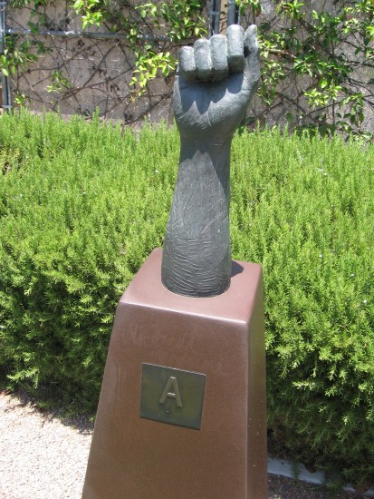 Bronze hand signs the letter A.