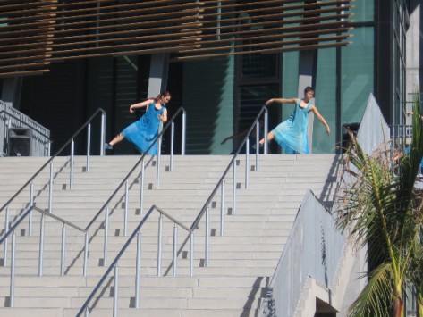 Dancers in flowing blue appear at the top of the broad steps!