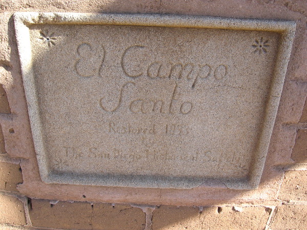 Sign in wall that encloses El Campo Santo.