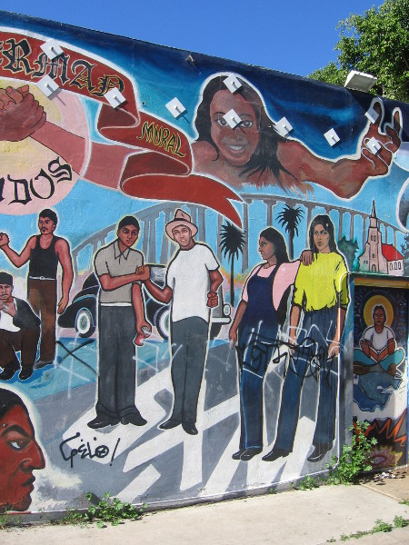 Words above people read Barrio Sherman Mural Unidos.
