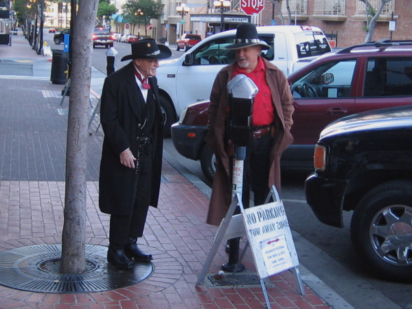 Two gentleman from the Old West converse on Fourth Avenue in San Diego's modern Gaslamp Quarter.