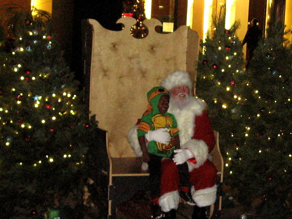 Santa and kid enjoy a special Deck the Halls neighborhood block party in downtown San Diego.
