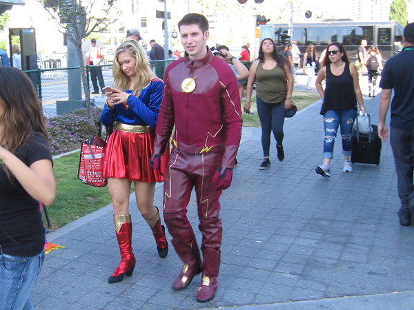 I spotted Flash and Supergirl ambling slowly along during San Diego Comic-Con. It appears Supergirl is getting an urgent communication from the Justice League Watchtower.