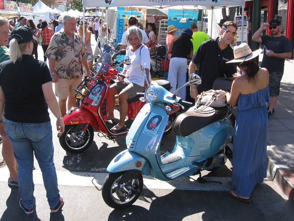 People at Festa check out some shiny new Vespas.