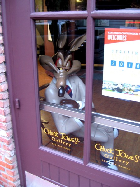 Wile E. Coyote in a business suit disguise. He secretly peers out of a window at the Chuck Jones Gallery. He's hoping The Road Runner might zoom on by.