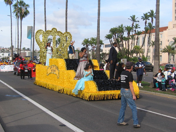 Here comes a bright yellow float carrying some beauty queens!