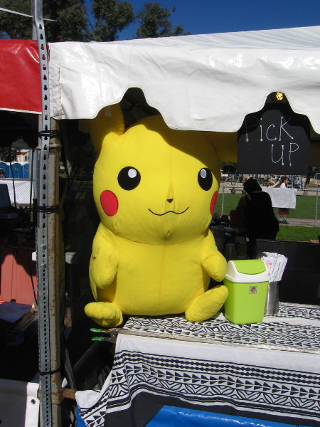 Pikachu sits protecting a spot where food is picked up.