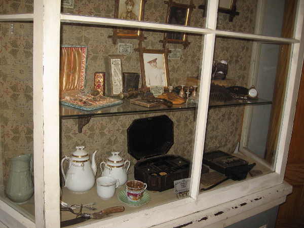 A nearby display case contains items belonging to various members of the Whaley family, including engraved silverware and china.