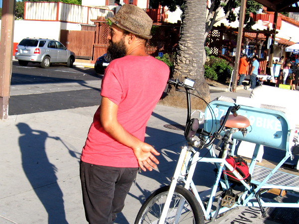 A pedicab driver relaxes while awaiting some business.