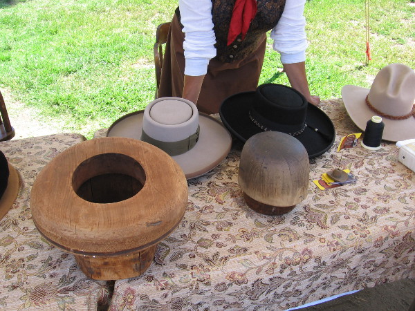 A hat maker shows how beaver felt material was steamed then pushed over a hat-form block.