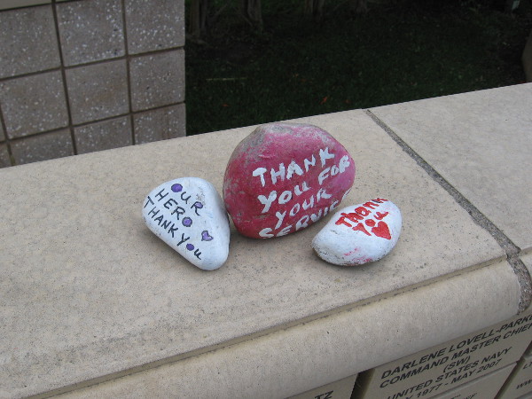 Painted on three small stones are words of Thank You for the service of heroes.