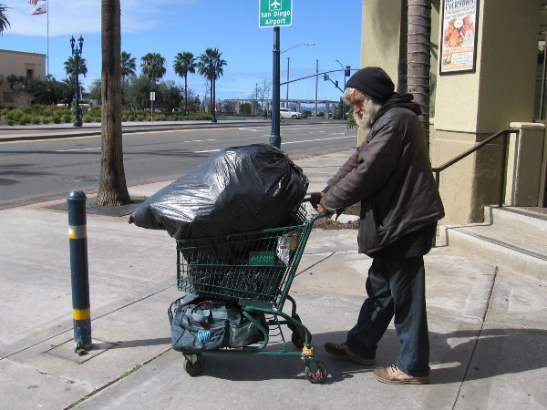 Homeless man walks through life with his stuff.