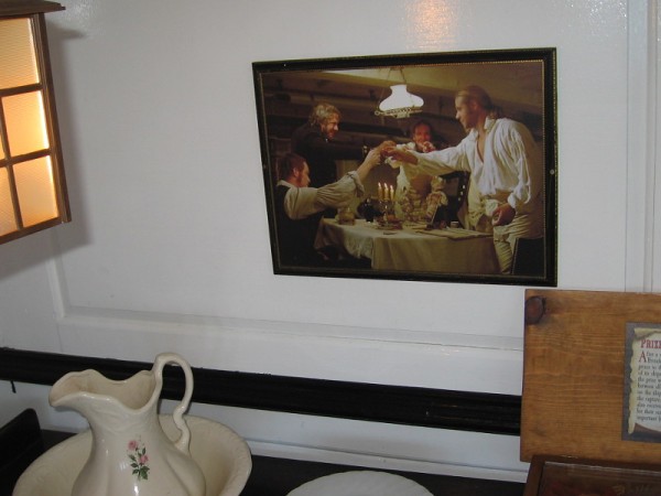 Photo on wall recalls a scene in Master and Commander. Captain Jack Aubrey shares a toast with ship's doctor and officers.