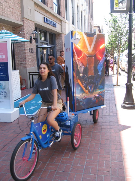 Here comes a small mobile billboard towed by a bicycle. Cool graphic, whatever the heck you're promoting.
