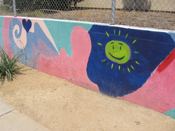 Happy sun painted on a long colorful wall at Perkins Elementary School.