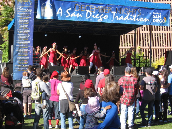 A group of children called Let's Dance for Fun! performs at the small December Nights stage near the Botanical Building.