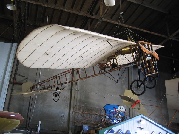 Bleriot XI dangles from the ceiling. The revolutionary 1908 aircraft had a new Anzani engine that could run for one whole hour, allowing it to fly across the English Channel.