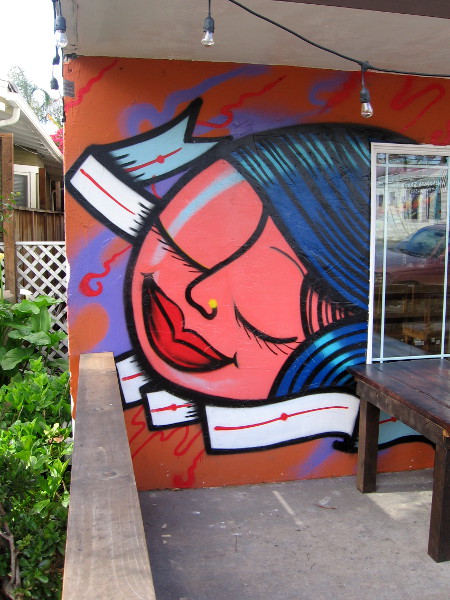 A bold, contented face painted by the entrance to Dia Del Cafe.