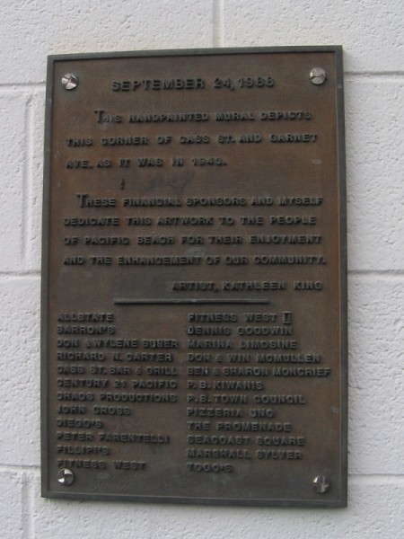 Plaque explains the mural depicts the corner of Cass Street and Garnet Avenue as it was in 1943.