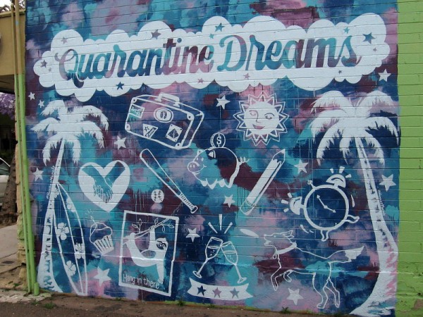 Quarantine Dreams mural in La Jolla. When quarantined due to coronavirus, you can't travel, dine, date, surf, play sports, or even play outside with the dog. Hang in there!