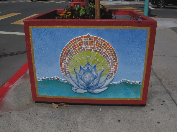 Planter on sidewalk with tile mosaic depicting a lotus, symbol of divine beauty. The lotus is Vietnam's national flower.